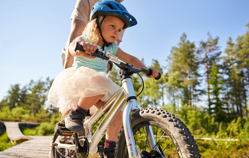 Bilden visar en liten tjej som cyklar i teknikområde Sågverket i Södra Berget Bike Arena.