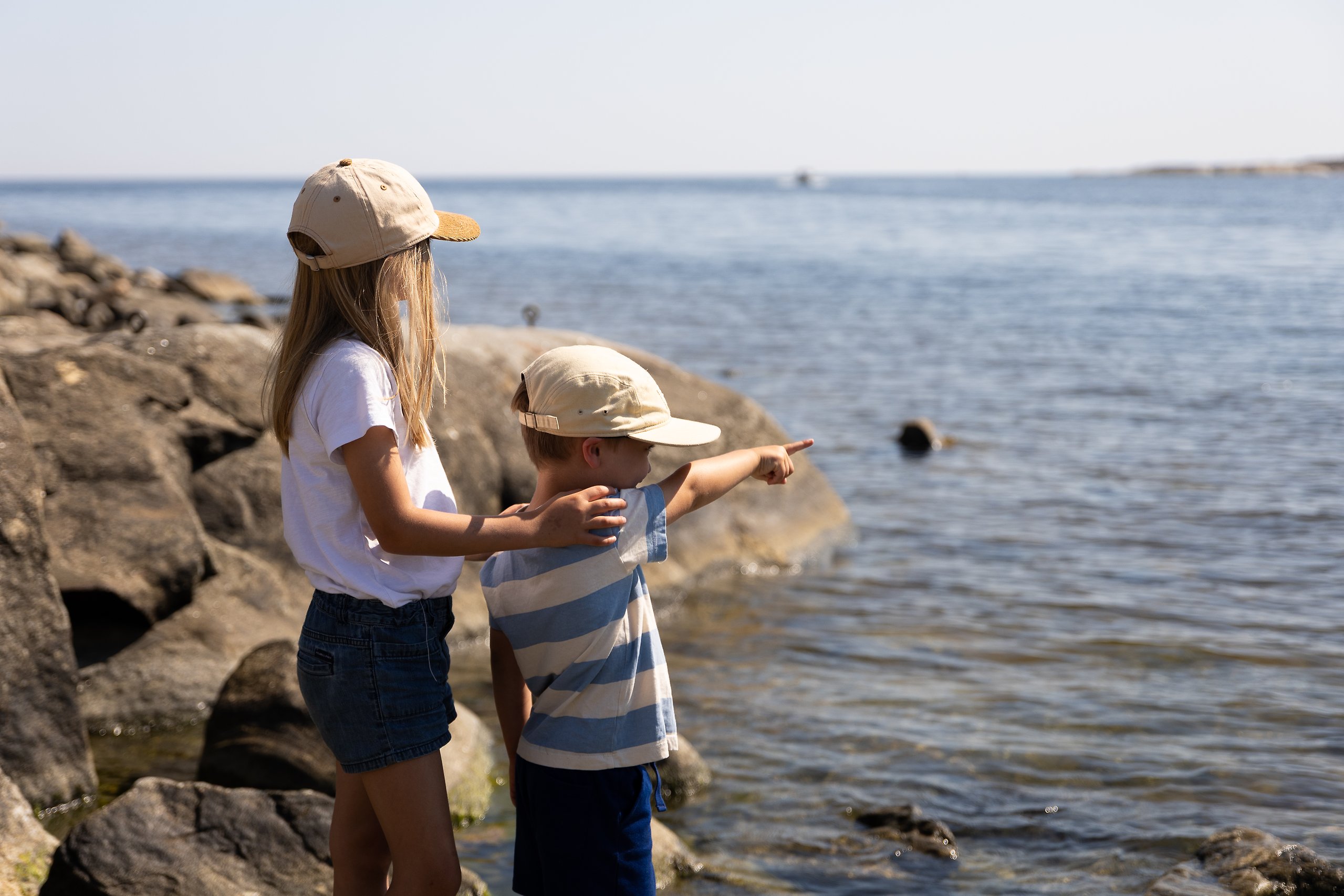 Barn vid havet som pekar ut över vattnet