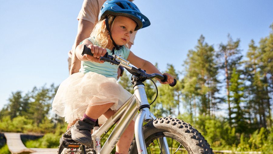 Bilden visar en liten tjej som cyklar i teknikområde Sågverket i Södra Berget Bike Arena.
