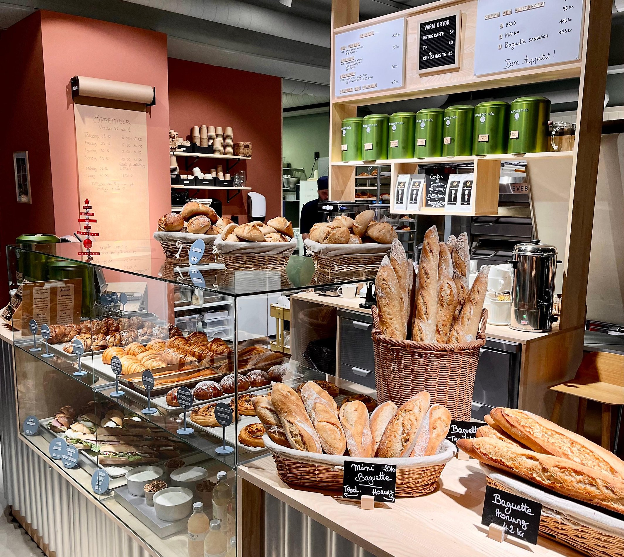 Ett foto av en kassadisk, fylld med bröd och fika på ett Kafé.