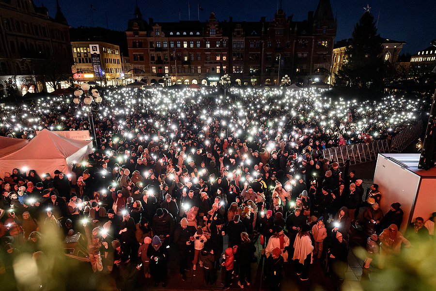 Stora torget i Sundsvall fyllt av människor som lyser med sina mobiltelefoner