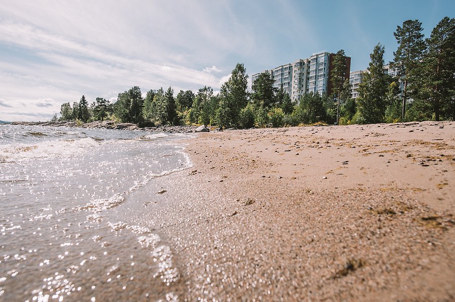 Sandstrand med höghus i bakgrunden